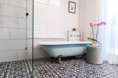 Inredning av ett klassiskt stort en-suite badrum, med ett badkar med tassar, en dusch i en alkov, vit kakel, porslinskakel, vita väggar, klinkergolv i porslin, svart golv och dusch med gångjärnsdörr