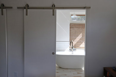 Mid-sized minimalist master white floor freestanding bathtub photo in Denver with white walls