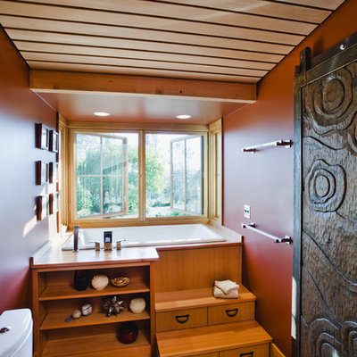 Country 3/4 medium tone wood floor japanese bathtub photo in San Francisco with medium tone wood cabinets, a two-piece toilet and red walls