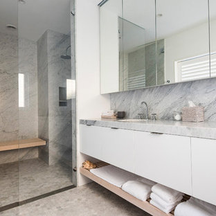 Beach style bathroom in Sydney with flat-panel cabinets, white cabinets, an alcove shower, gray tile, white walls, mosaic tile floors, an undermount sink, grey floor, a hinged shower door and grey benchtops.