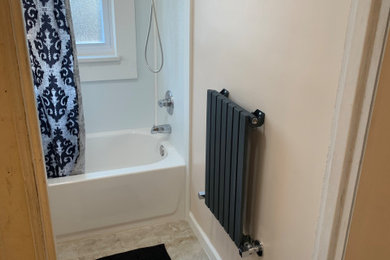 Example of a small trendy porcelain tile, beige floor and single-sink bathroom design with raised-panel cabinets, white cabinets, a two-piece toilet, beige walls, a console sink, quartz countertops, white countertops and a freestanding vanity