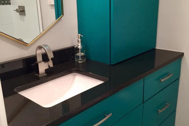 Modern ensuite bathroom with flat-panel cabinets, blue cabinets, granite worktops and black worktops.