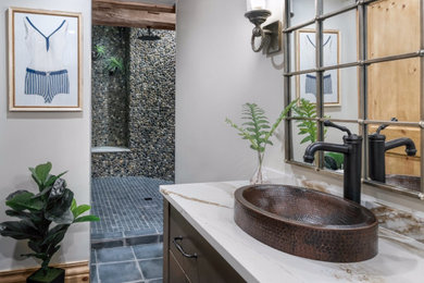 Example of a mid-sized mountain style ceramic tile and gray floor bathroom design with brown cabinets, a vessel sink, quartz countertops and white countertops