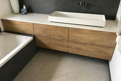 Modernes Duschbad mit hellbraunen Holzschränken