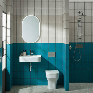 Photo of a contemporary bathroom in Other with a one-piece toilet, beige tiles, blue tiles, white tiles, metro tiles, multi-coloured walls, a wall-mounted sink, grey floors and an open shower.