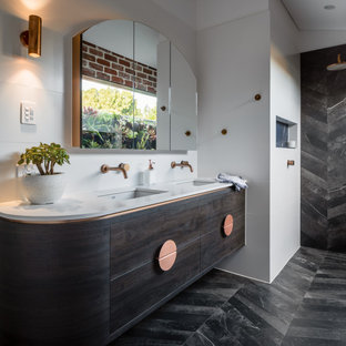 This is an example of an industrial bathroom in Perth with engineered quartz benchtops, white benchtops, flat-panel cabinets, dark wood cabinets, a curbless shower, white walls, an undermount sink, black floor, an open shower, a double vanity, a floating vanity and vaulted.