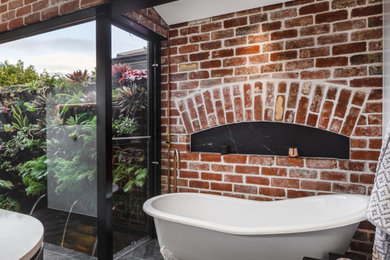 パースにある高級なインダストリアルスタイルのおしゃれな浴室 (猫足バスタブ、クオーツストーンの洗面台、白い洗面カウンター、黒い床) の写真