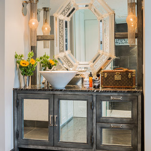 This is an example of an industrial bathroom in Boston with a vessel sink, glass-front cabinets, grey cabinets and gray tile.