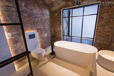Foto de cuarto de baño industrial con bañera exenta, ducha abierta, suelo de baldosas de porcelana y suelo beige