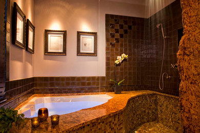 Cette image montre une petite salle de bain design avec un placard avec porte à panneau surélevé, un plan de toilette en granite, une baignoire d'angle, une douche ouverte, un carrelage marron, un carrelage en pâte de verre et un sol en carrelage de terre cuite.