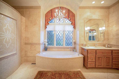 Alcove bathtub - mid-sized traditional master beige tile and limestone tile limestone floor and beige floor alcove bathtub idea in Raleigh with raised-panel cabinets, medium tone wood cabinets, a two-piece toilet, beige walls, an undermount sink and limestone countertops