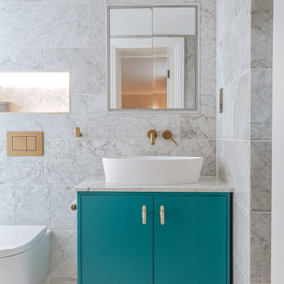 Photo of a large contemporary master bathroom in London with flat-panel cabinets, turquoise cabinets, an open shower, a wall-mount toilet, gray tile, ceramic tile, grey walls, ceramic floors, a vessel sink, marble benchtops, white floor, an open shower, grey benchtops, a single vanity and a freestanding vanity.