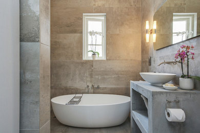 Foto de cuarto de baño contemporáneo pequeño con bañera exenta, baldosas y/o azulejos grises, baldosas y/o azulejos de cemento, suelo de cemento, aseo y ducha y encimera de cemento