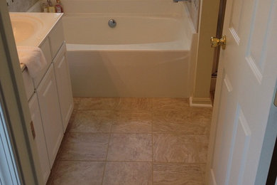 Small trendy beige tile alcove bathtub photo in Other with a drop-in sink, white cabinets and beige walls