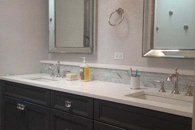 Example of a mid-sized trendy master subway tile linoleum floor alcove shower design in Chicago with recessed-panel cabinets, black cabinets, white walls, an undermount sink and marble countertops