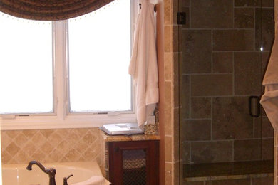 ミネアポリスにある高級な中くらいなトラディショナルスタイルのおしゃれなマスターバスルーム (ドロップイン型浴槽、アルコーブ型シャワー、ベージュのタイル、セラミックタイル、茶色い壁、セラミックタイルの床、茶色い床、開き戸のシャワー) の写真