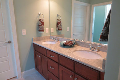 Inspiration for a mid-sized bathroom remodel in Raleigh with a drop-in sink, dark wood cabinets and green walls