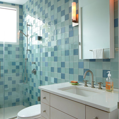 Example of a minimalist blue tile and glass tile alcove shower design in New York with an undermount sink, flat-panel cabinets and white cabinets