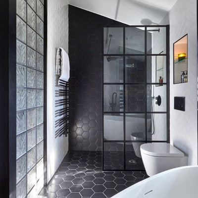 Bathroom - mid-sized contemporary master black and white tile and porcelain tile black floor and porcelain tile bathroom idea in London with a wall-mount toilet, white walls, furniture-like cabinets, medium tone wood cabinets, a vessel sink and wood countertops