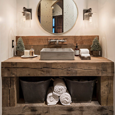 Mid-sized mountain style 3/4 black and white tile and cement tile cement tile floor bathroom photo in Phoenix with furniture-like cabinets, distressed cabinets, a two-piece toilet, white walls, a vessel sink and wood countertops