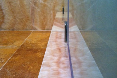 Immagine di una stanza da bagno con doccia minimal di medie dimensioni con consolle stile comò, ante in legno scuro, doccia doppia, WC monopezzo, piastrelle beige, lastra di pietra, pareti blu, pavimento in marmo, lavabo integrato e top in vetro