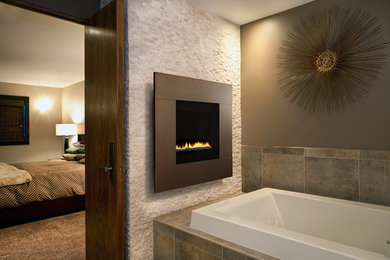 Trendy master beige tile and stone tile drop-in bathtub photo in Milwaukee with brown walls