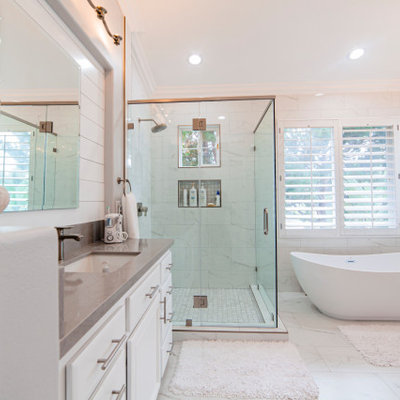 Large minimalist master white tile and marble tile marble floor and white floor bathroom photo in Los Angeles with shaker cabinets, white cabinets, white walls, an undermount sink, a hinged shower door and brown countertops
