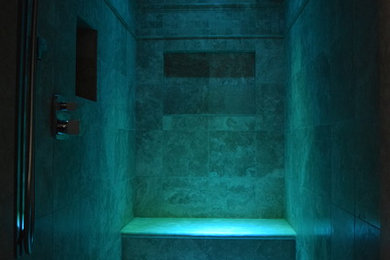 Idee per una grande sauna mediterranea con ante in legno scuro, vasca da incasso, piastrelle beige, pareti blu, pavimento in travertino e lavabo sottopiano