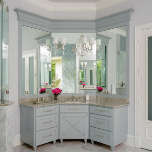 Modelo de cuarto de baño principal, clásico renovado, grande, con armarios estilo shaker, paredes grises, lavabo bajoencimera, puertas de armario grises, bañera exenta, ducha esquinera, suelo de mármol, encimera de cuarcita, suelo blanco, ducha con puerta con bisagras y encimeras grises