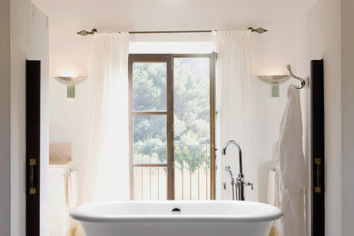 Modelo de cuarto de baño principal contemporáneo de tamaño medio con bañera exenta, paredes blancas, suelo de baldosas de cerámica y suelo beige