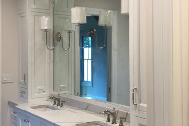 Modelo de cuarto de baño principal con armarios estilo shaker, puertas de armario blancas, lavabo bajoencimera, encimera de mármol y encimeras blancas