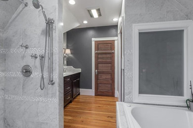 Example of a mid-sized transitional master gray tile and marble tile light wood floor and brown floor bathroom design in Other with raised-panel cabinets, dark wood cabinets, gray walls, an undermount sink, marble countertops and gray countertops