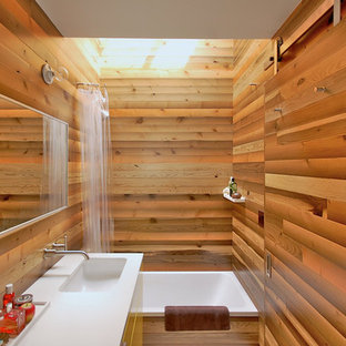Diseño de cuarto de baño principal, asiático, de tamaño medio, con lavabo bajoencimera, armarios con paneles lisos, bañera encastrada, combinación de ducha y bañera, paredes marrones, encimera de cuarcita, puertas de armario amarillas y ducha con cortina