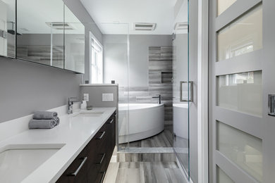 Bathroom - mid-sized modern master gray tile and porcelain tile porcelain tile and gray floor bathroom idea in New York with flat-panel cabinets, black cabinets, a wall-mount toilet, gray walls, an undermount sink, quartz countertops, a hinged shower door and white countertops