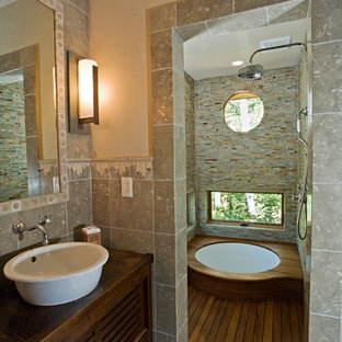Exemple d'une petit salle de bain principale montagne avec une vasque, un placard à porte plane, des portes de placard en bois brun, un plan de toilette en bois, un bain japonais, une douche à l'italienne, un WC à poser, un carrelage de pierre, un mur vert, un sol en calcaire et un carrelage gris.