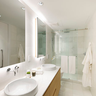 Immagine di una stanza da bagno padronale minimalista di medie dimensioni con ante lisce, ante in legno chiaro, piastrelle bianche, lastra di pietra, lavabo a bacinella, top in marmo, doccia alcova, WC a due pezzi, pareti bianche, pavimento in marmo e vasca da incasso