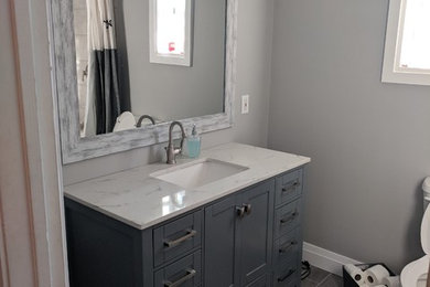 他の地域にあるコンテンポラリースタイルのおしゃれな浴室 (グレーのキャビネット、グレーの壁、グレーの床、白い洗面カウンター) の写真