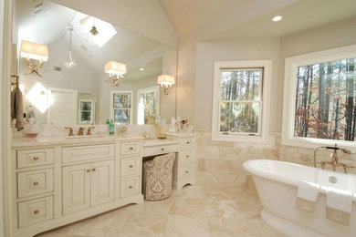 Photo of a large traditional ensuite bathroom in Atlanta with white cabinets, a freestanding bath, beige tiles, beige walls, a submerged sink, beige floors, a hinged door, white worktops, beaded cabinets, a built-in shower, a one-piece toilet, marble tiles, marble flooring and marble worktops.