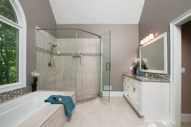 Idée de décoration pour une grande salle de bain principale design avec un placard avec porte à panneau surélevé, des portes de placard blanches, une baignoire posée, une douche d'angle, un carrelage beige, des carreaux de porcelaine, un mur gris, un sol en carrelage de porcelaine, un lavabo encastré, un plan de toilette en granite, un sol beige et une cabine de douche à porte battante.