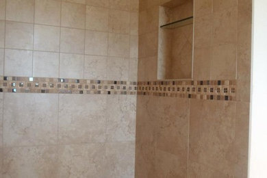 Immagine di una stanza da bagno mediterranea di medie dimensioni con doccia alcova, piastrelle di marmo, pareti beige e pavimento beige