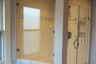 グランドラピッズにある広いトラディショナルスタイルのおしゃれな浴室 (ドロップイン型浴槽、ベージュのタイル、モザイクタイル、大理石の床) の写真