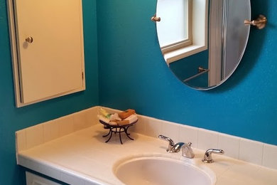 Example of a mid-sized transitional 3/4 porcelain tile and beige floor bathroom design in Seattle with beaded inset cabinets, white cabinets, blue walls, an undermount sink and tile countertops