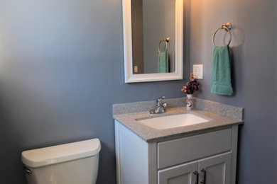 Cette photo montre une salle de bain chic de taille moyenne avec un placard à porte plane, des portes de placard blanches, un sol en vinyl, un lavabo encastré, un plan de toilette en onyx, un sol gris, une cabine de douche avec un rideau et un plan de toilette gris.