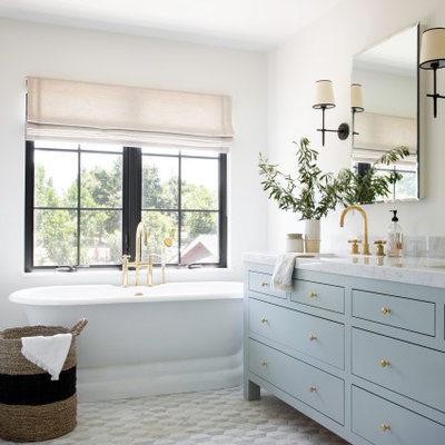 Beach style master gray floor and double-sink freestanding bathtub photo in San Francisco with furniture-like cabinets, blue cabinets, white walls, an undermount sink, white countertops and a freestanding vanity