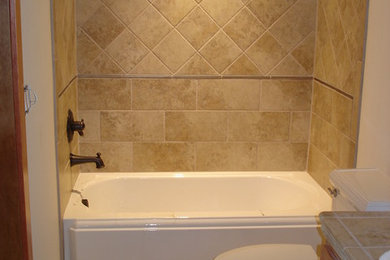 Inspiration for a mid-sized transitional beige tile and ceramic tile ceramic tile bathroom remodel in Other with a two-piece toilet, beige walls, shaker cabinets, medium tone wood cabinets, a drop-in sink and tile countertops