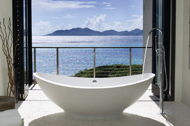 Large island style master beige tile pebble tile floor freestanding bathtub photo in Other with white walls