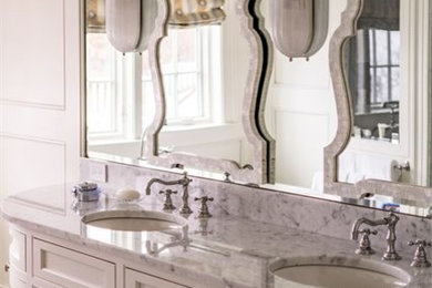 ボストンにある高級なトランジショナルスタイルのおしゃれな浴室 (落し込みパネル扉のキャビネット、白いキャビネット、白い壁、オーバーカウンターシンク、大理石の洗面台) の写真