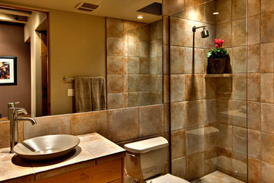 Cette image montre une salle de bain principale design de taille moyenne avec un placard à porte shaker, des portes de placard beiges, une douche ouverte, un carrelage beige, des carreaux de porcelaine, un mur beige, un sol en carrelage de porcelaine, une vasque, un plan de toilette en carrelage, un sol beige et aucune cabine.