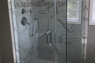 Corner shower - mid-sized traditional master gray tile and ceramic tile ceramic tile and gray floor corner shower idea in Baltimore with raised-panel cabinets, gray cabinets, a two-piece toilet, gray walls, an undermount sink, quartz countertops and a hinged shower door