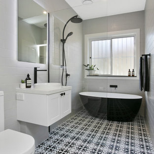 Design ideas for a mid-sized transitional wet room bathroom in Sydney with white cabinets, gray tile, porcelain tile, white walls, porcelain floors, a vessel sink, engineered quartz benchtops, an open shower, white benchtops, a freestanding tub, a two-piece toilet and multi-coloured floor.